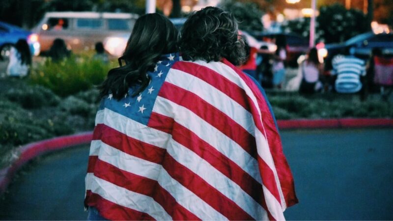 アメリカ国旗を覆いかぶさっている男女二人